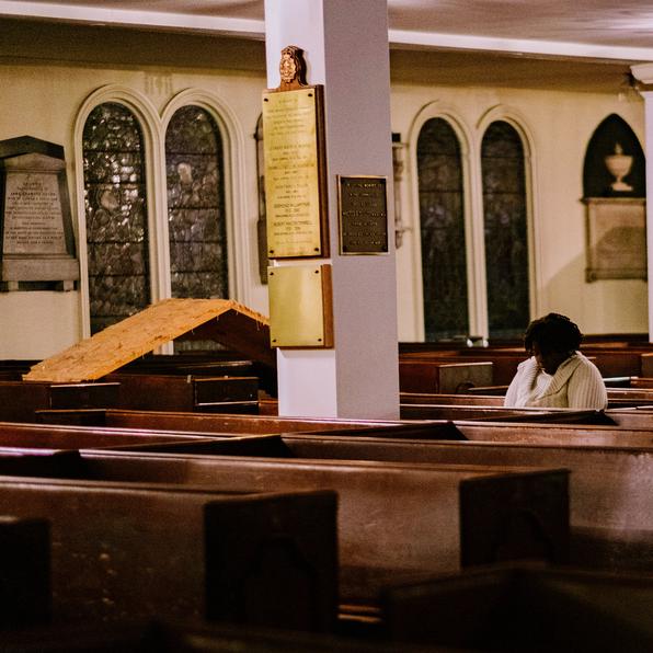 A woman prays in a church.
